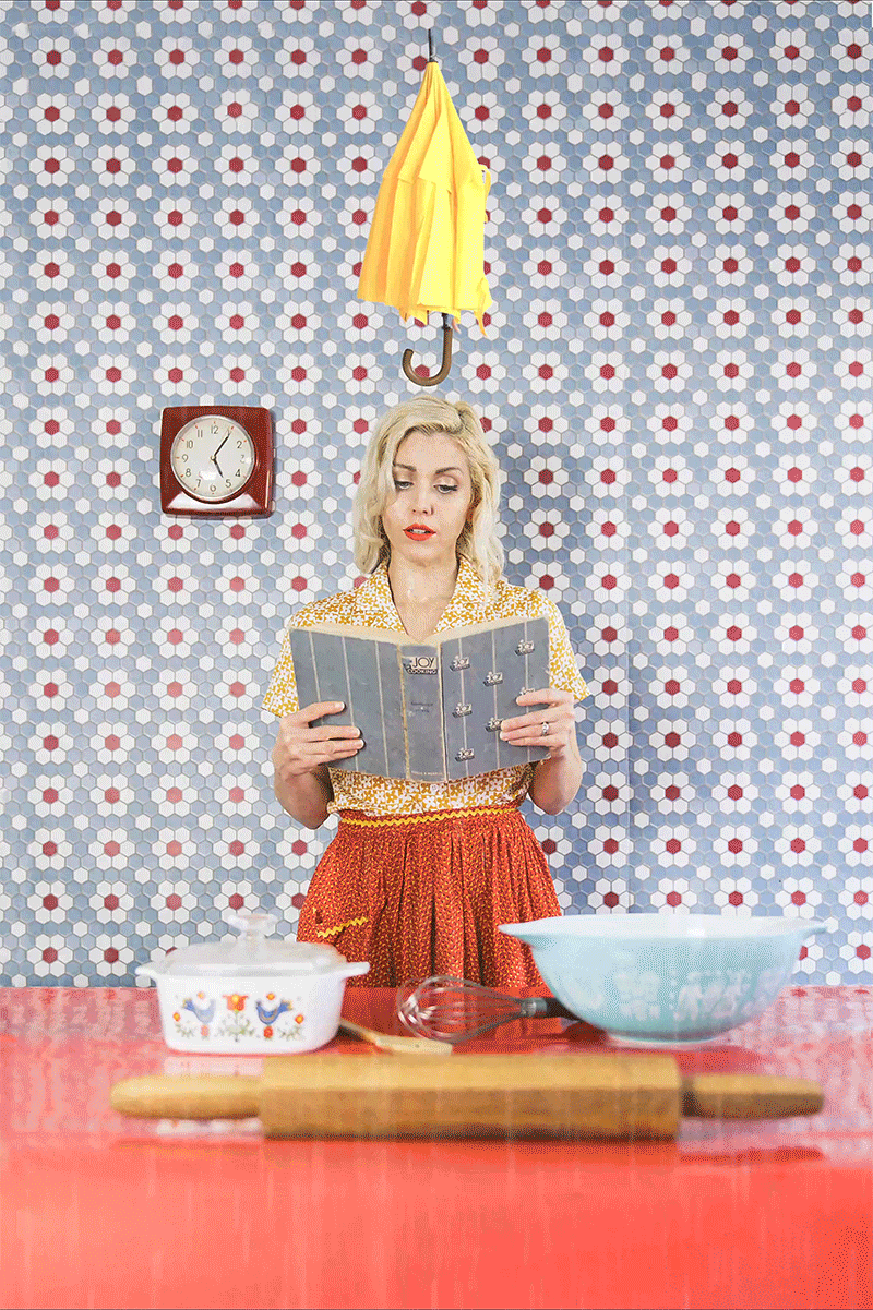tenleyclark-sonyalphafemale-undertheweather-rain Cinemagraph of mother reading a recipe as it begins to rain and an umbrella opens over her head