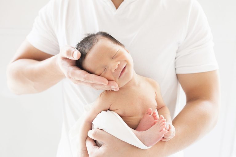 man holding newborn baby