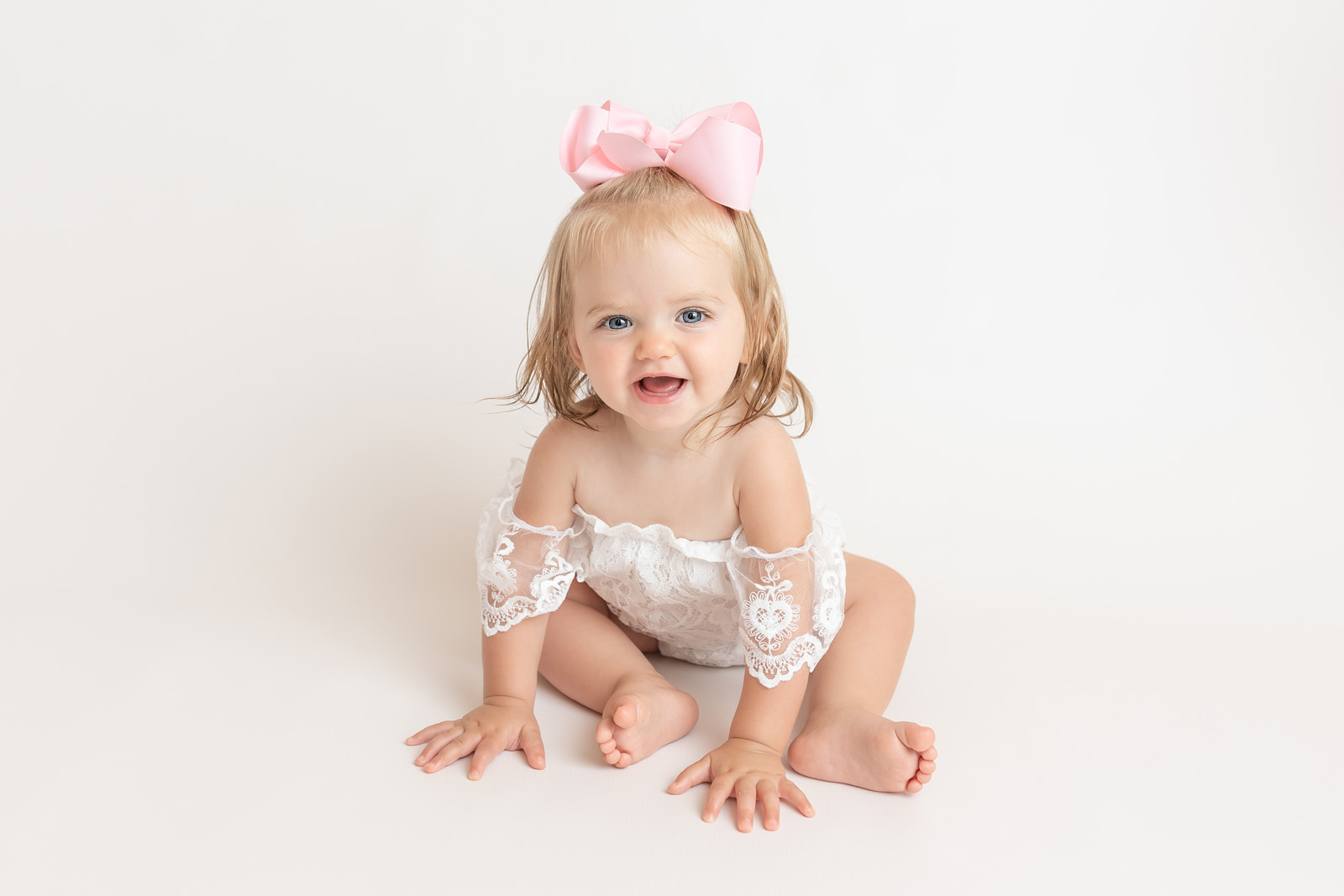 one year photo session with baby girl wearing pink bow