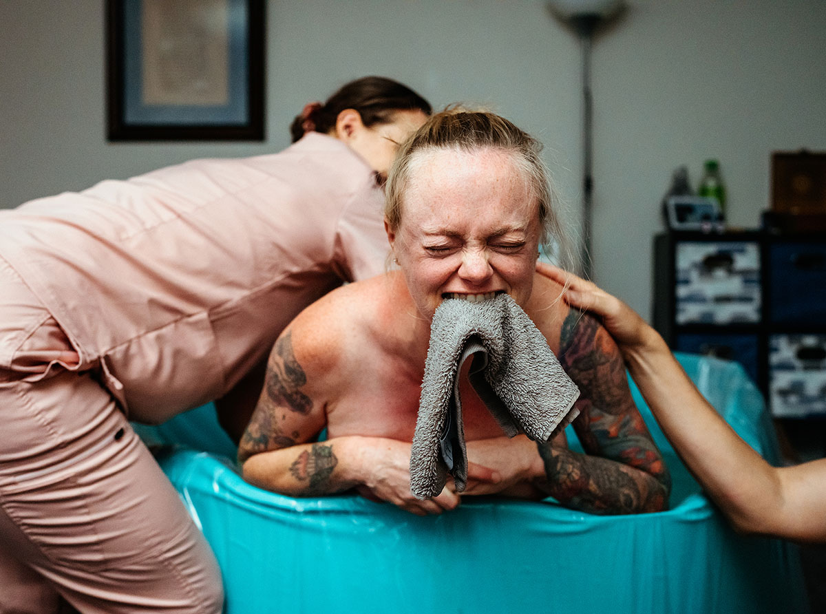 255-BIRTH_WEINGARDT_L_15 LISA WEINGARDT birth photographer captures woman giving birth while biting washcloth