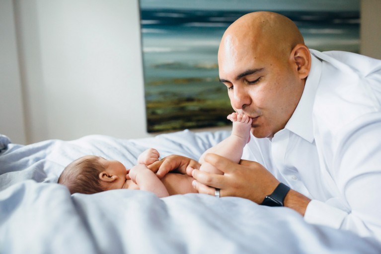 Dad kisses baby's foot at an in-home newborn session