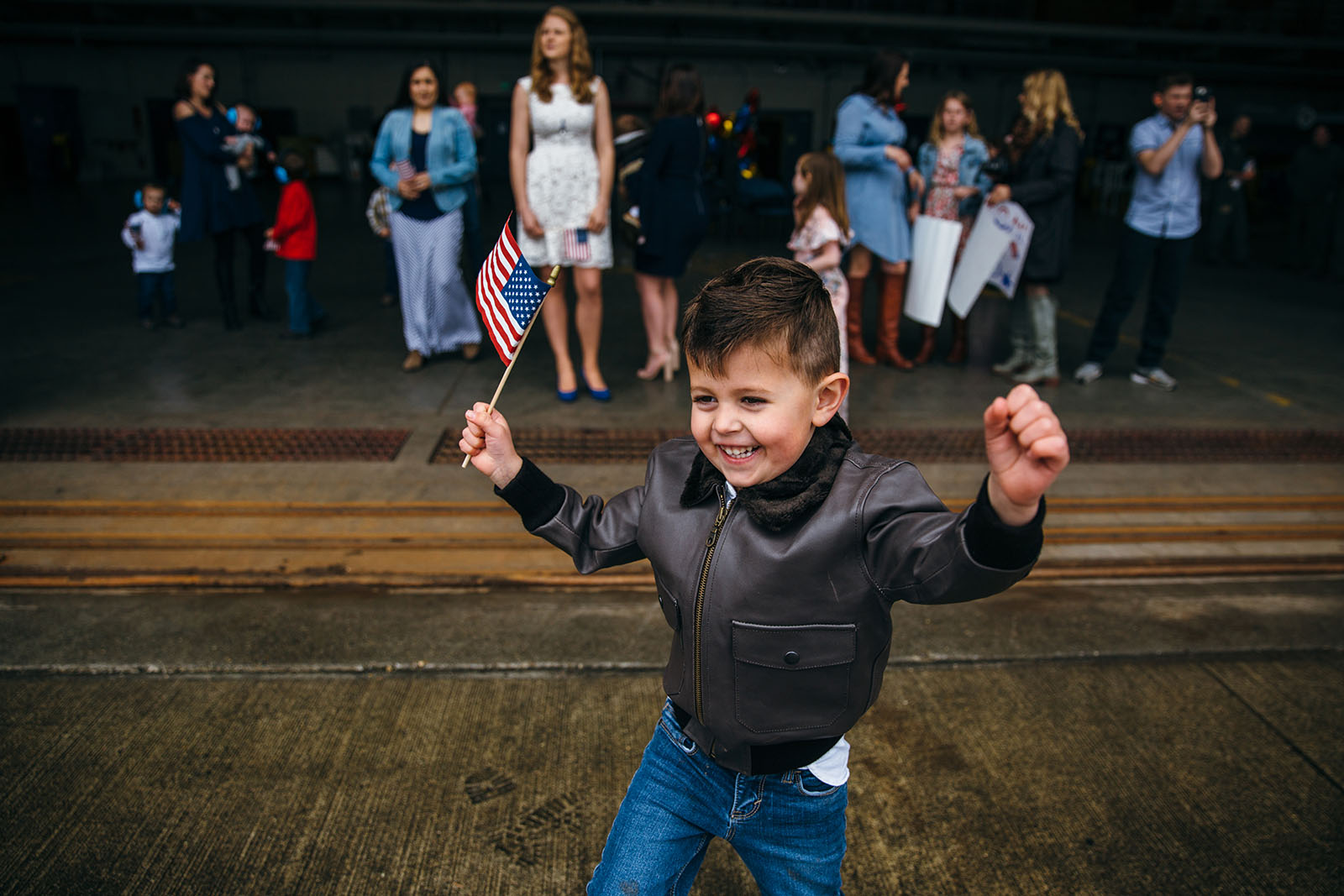 boy-celebrates-with-flag-during-military-homecoming-by-Kara-Chappell A little boy waits for his father at a military homecoming