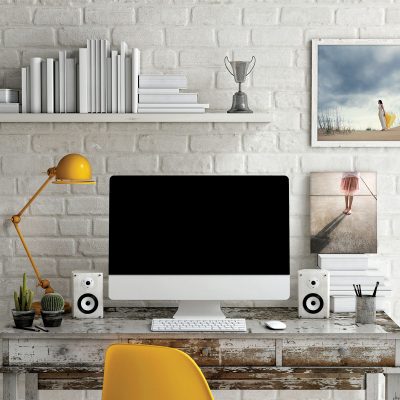 distressed desk against a white brick wall