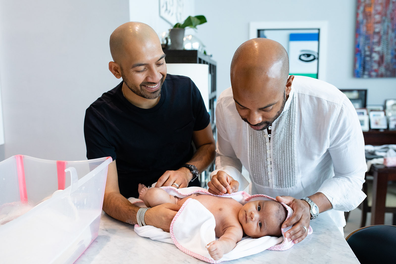 Dads bathe their baby during in-home newborn photo session