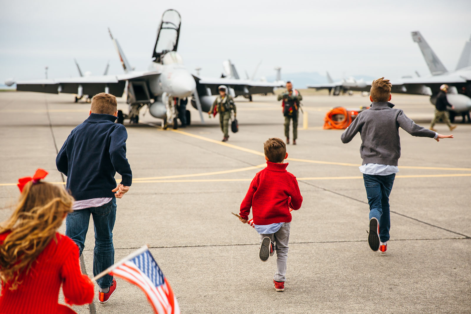 four-children-run-towards-father-on-flight-line-by-Kara-Chappell