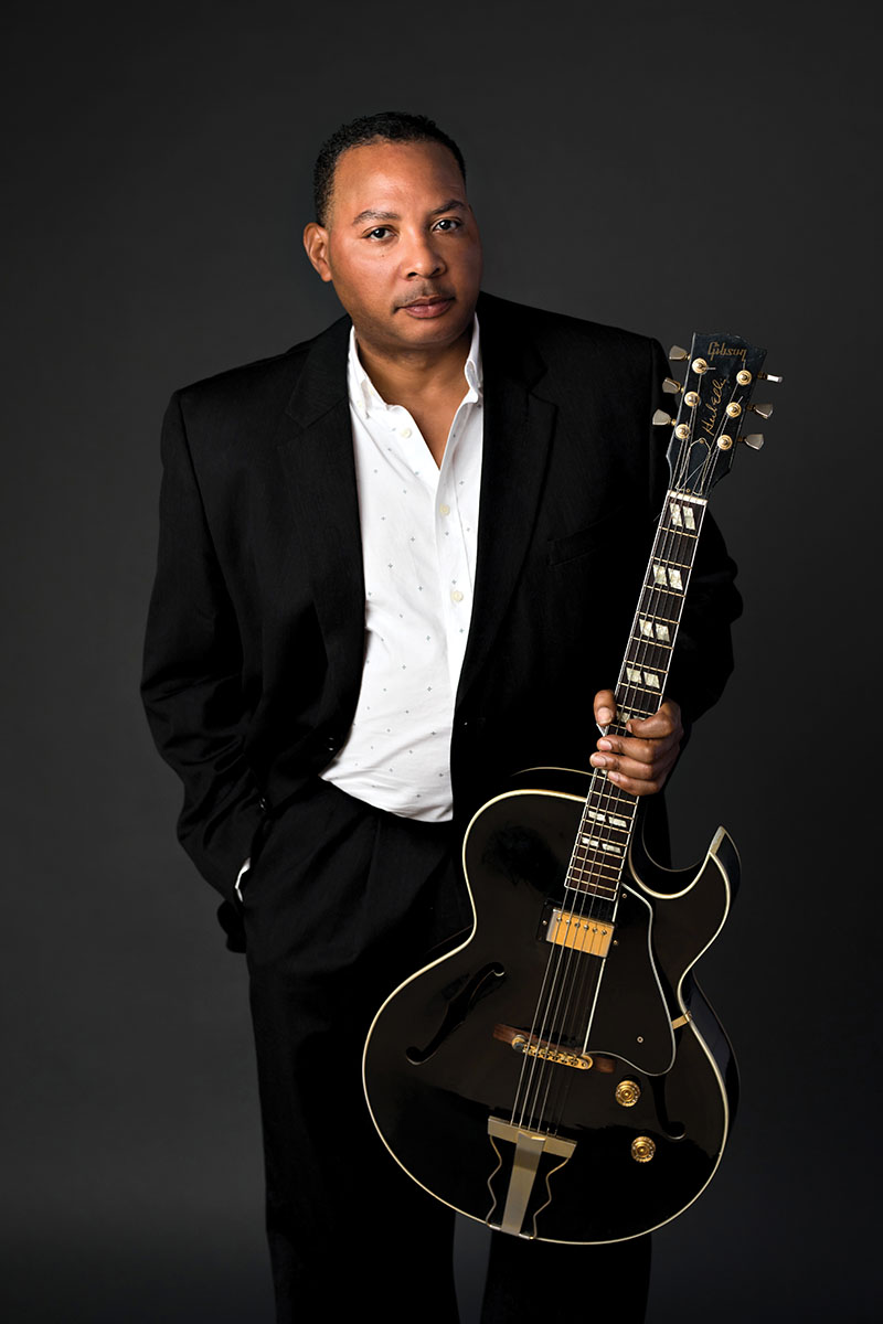 Headshot of a musician with his guitar