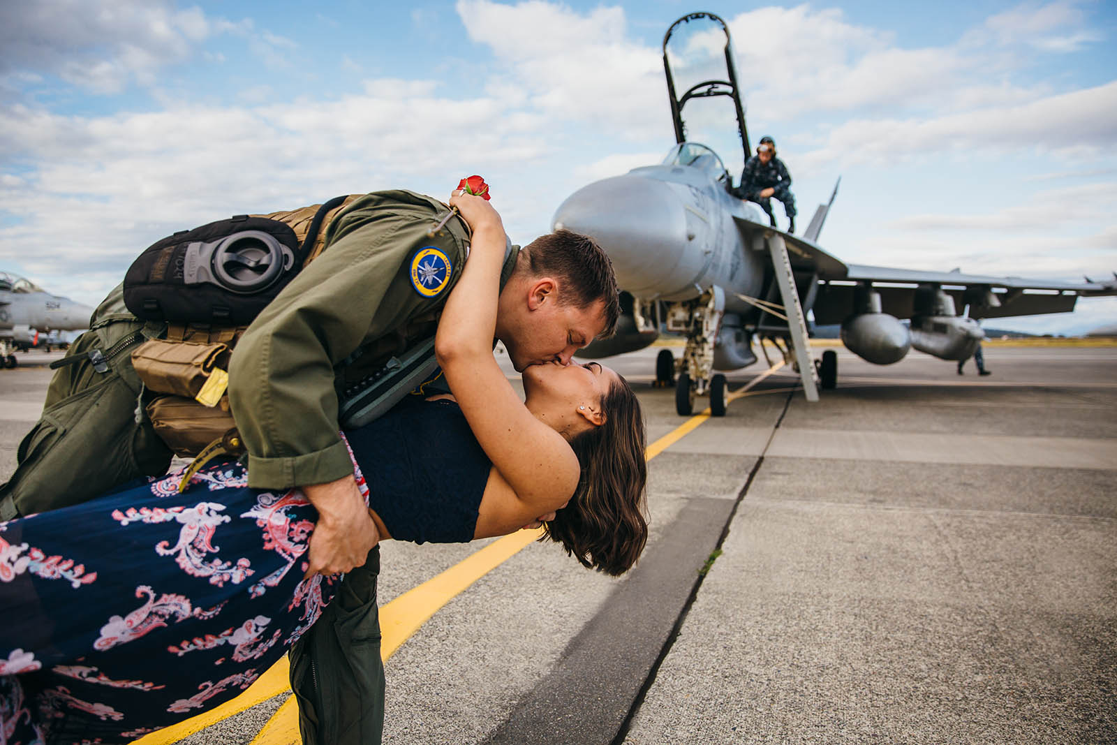 man-dips-and-kisses-wife-in-front-of-plane-at-military-homecoming-by-Kara-Chappell