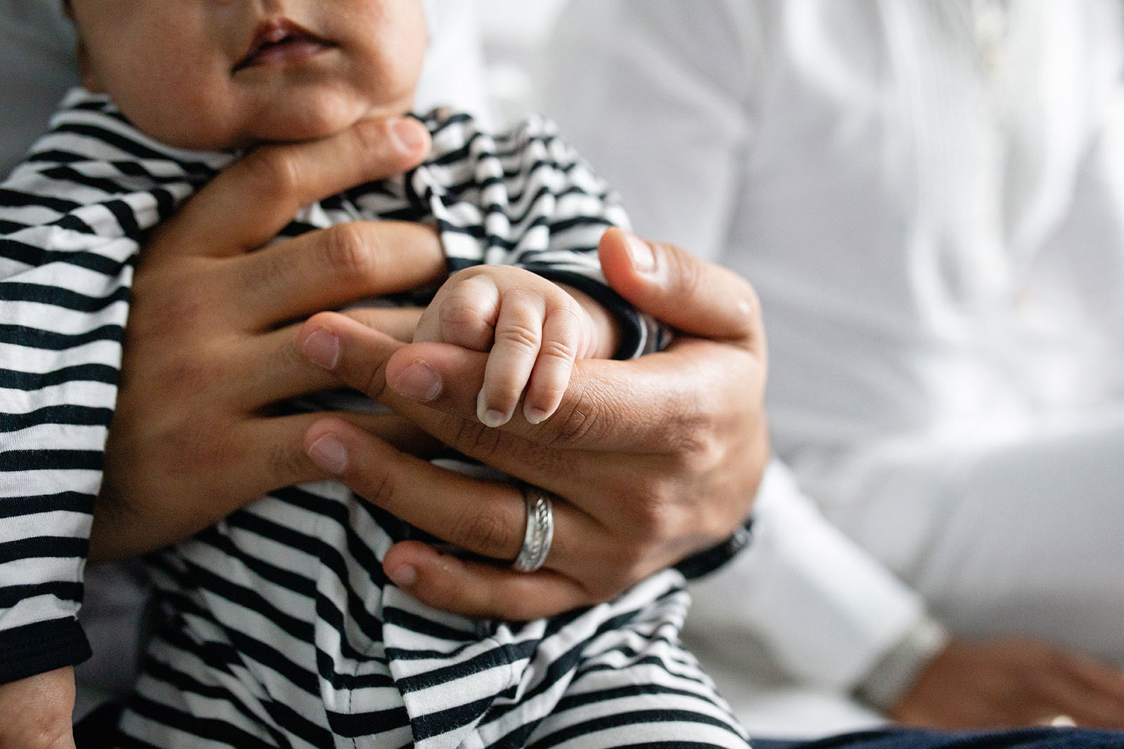 Baby's finger hold's dad's hand