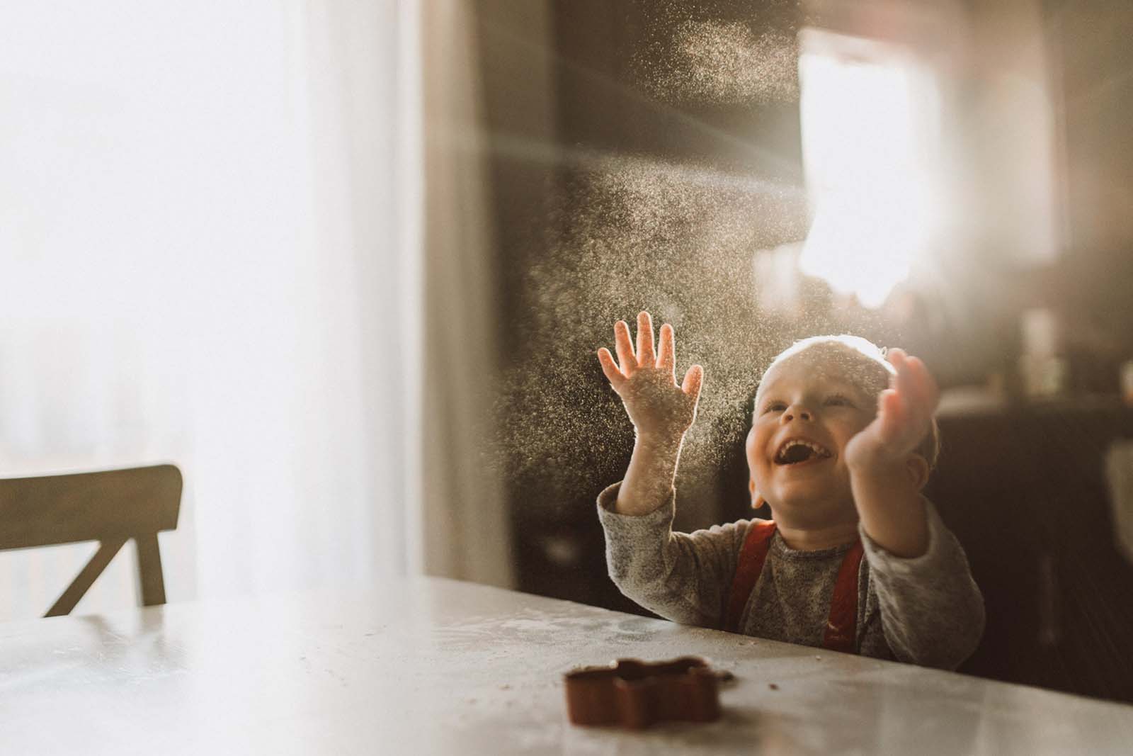 A joyful boy through a window. Finding balance with photography and motherhood