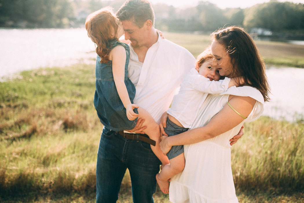 portrait of family hugging in a field by Elise Meader