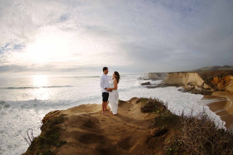 Travel session photo of a couple standing on a cliff taken in Davenport California