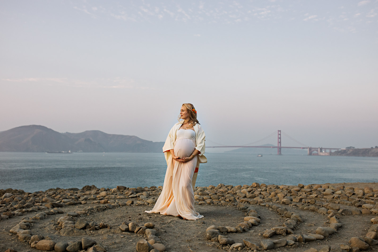 pregnant woman stands in front of the Golden Gate bridge